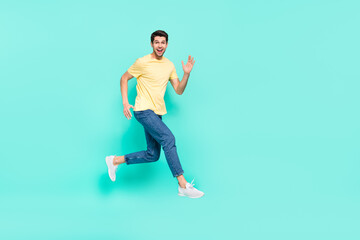 Fototapeta na wymiar Full body profile portrait of excited energetic man running hurry speed isolated on teal color background