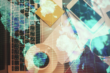 Business theme hologram drawings over computer on the desktop background. Top view. Multi exposure. Concept of international connections.
