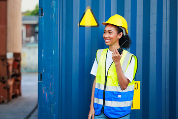 Black female dock worker control loading containers box from cargo at warehouse container yard....
