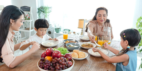 Asian happy family spend time having lunch on table together.  relationship and activity in house.