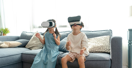 Asian child feeling excited while using 360 VR headset for virtual reality, Metaverse at home.