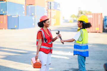 Two African american female mechanic working in car service and maintenance workshop. Mechanical fix car truck warehouse container yard