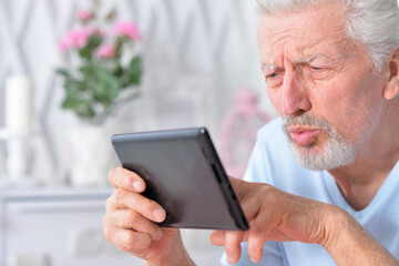  senior man using tablet at home