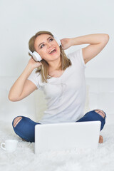  young woman wearing headphones   with  laptop computer on  the floor