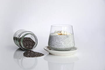 Chia seeds from the Salvia hispanica plant. Very healthy functional food to use in various recipes. Glass cup containing the seeds hydrated with natural yogurt. 