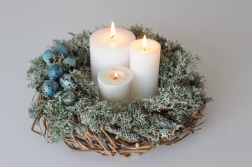Fototapeta na wymiar table composition - wreath with moss, decorated with eggs and candles