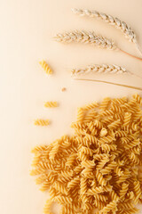 Traditional Italian fusilli pasta on a beige background. Dry uncooked pasta. Close-up.
