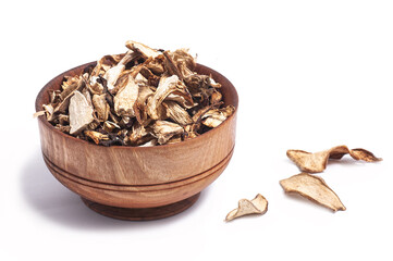 dried white mushroom slices in wooden bowl on white background.