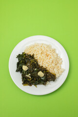 fried spinach with garlic and boiled rice on plate