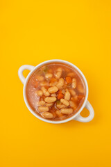 boiled white beans with vegetables and sauce on white bowl