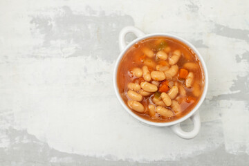 boiled white beans with vegetables and sauce on white bowl