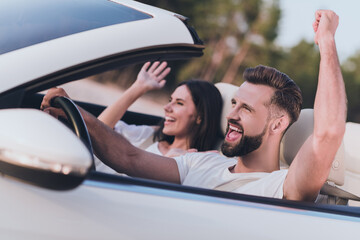 Photo of adorable lucky husband wife wear casual clothes riding cabriolet rising fist celebrating...