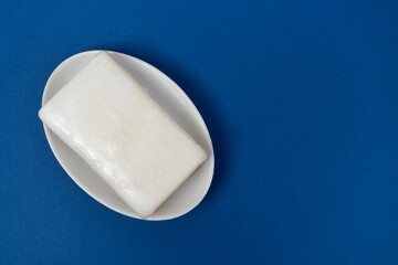 a bar of soap on a soap dish on a blue background	