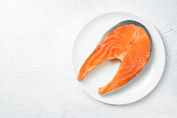 fresh trout steak on white plate on gray concrete background