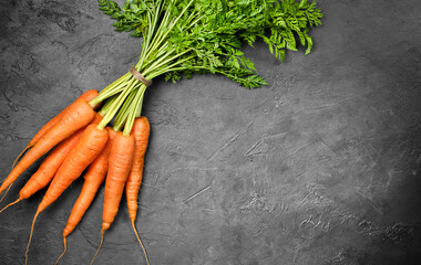 a bunch of carrots on a dark concrete background