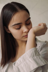 Delicate dreamy woman smelling essential oil scent from wrist while enjoying aromatherapy with...