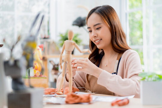 Asian Female spend weekend day for her hobby clay scuplture online course at home, young adult making study from tablet streaming course online in apron costume,asian casual lifestyle at home