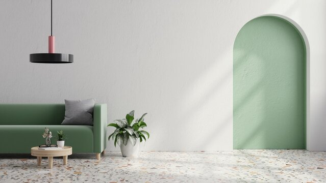 Green sofa with table on green wall and white wood flooring.