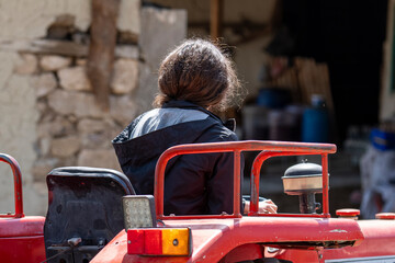 Woman driving the red tractor.