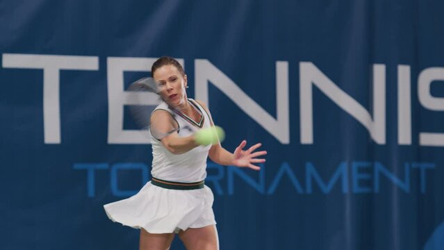 Female Tennis Player Hitting Ball with a Racquet During Championship Match. Professional Woman Athlete Receives and Lands Perfect Backhand Shot. World Sports Tournament. Slow Motion Full Shot Playback