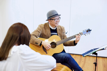 ギターを弾く日本人の男性と女性