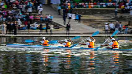 Intentional camera movement, pan image of speeding kayak with four young participants of COEP annual boat event regatta.