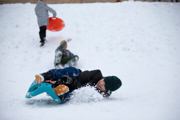 Fototapeta na wymiar Children in winter. Boys friends are sledding.