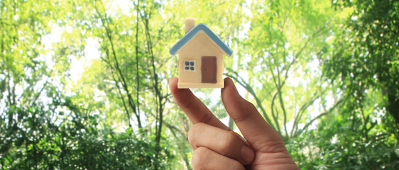 Hand holding  house model. property insurance and security Buy rent house concept
