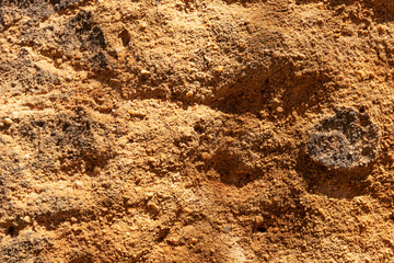 Texture of sandstone stone with scratches and cracks. Closeup