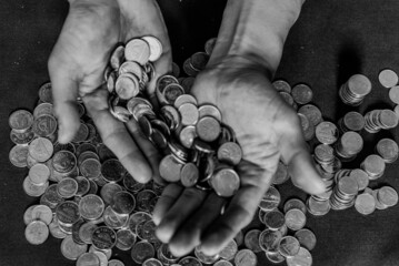 Grayscale shot of coins on male hands
