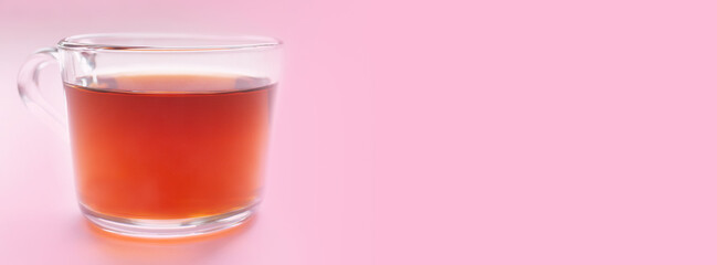 Banner with a cup of black tea on a pink background. Place for text. Copy space.