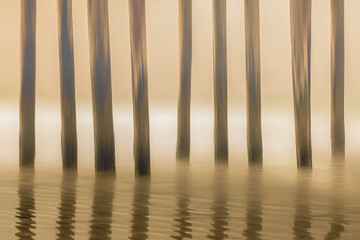 Poles in a row at the beach in California at sunset, long exposure and icm