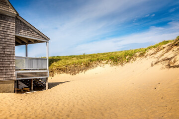 Fototapeta premium A part of the life saving station building in Provincetown with dand dunes and gras, copy space