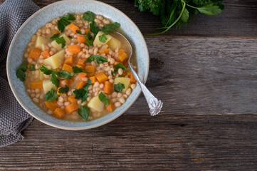 Vegan beans soup with potatoes and vegetable isolated on wooden table