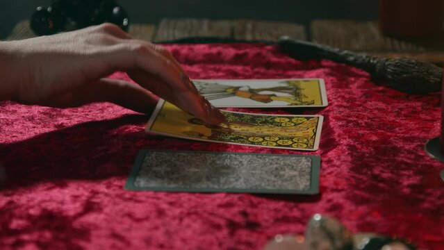 Laying out three cards on the table by a fortune teller during a divination session.