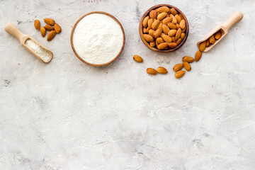 Gluten free almond flour with almond nuts in bowl, top view