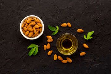 Almond oil and group of almond nuts with leaves