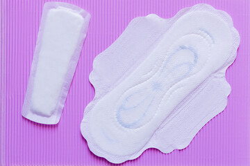 top view of white panty liners on violet textured background.
