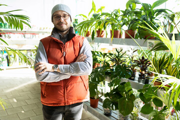 garden shop worker in front of shelves with potted plants