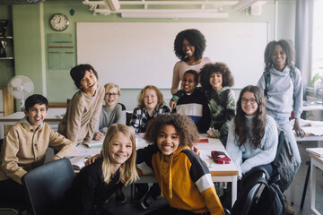 Group of diverse students with teacher in classroom