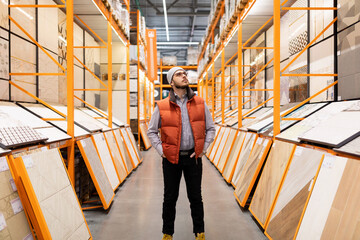 a buyer in a hardware store picks up ceramic tiles