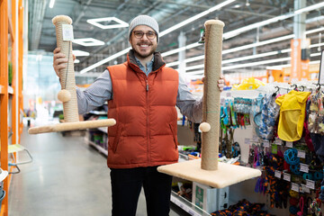 caring owner picks up a scratching post for his pet cat