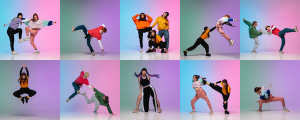 Stylish men and women dancing hip-hop in bright clothes on colorful background at dance hall in...