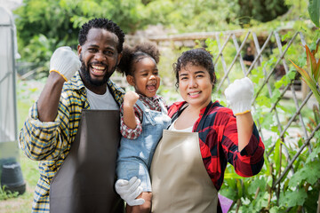 Cheerful young family spending time together at the farm, Happy parents with their little daughter outdoors in the field. 