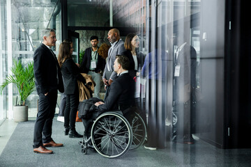 Corporate business professionals discussing during seminar in corridor at conference center