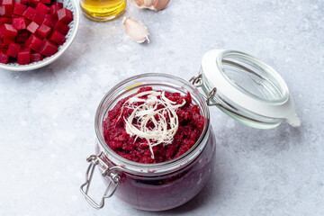 Homemade beet pesto sauce with horseradish in glass jar. Healthy vegetarian detox diet food