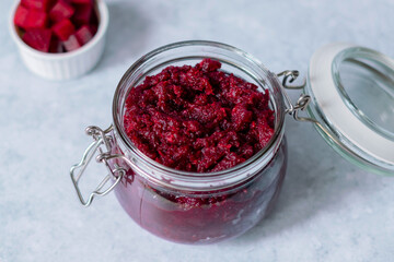 Homemade beet pesto sauce with horseradish in glass jar. Healthy vegetarian detox diet food