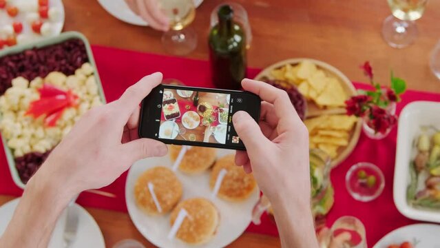 White person's hands taking photos of food on the table on smartphone 
