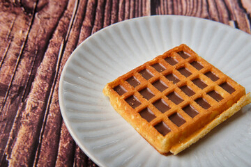 Chocolate & hazelnut flavour waffle from on a white plate.