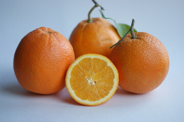 ripe and juicy orange. fresh orange cut in half on a background of oranges with leaves